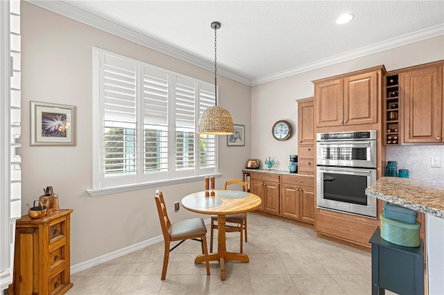 kitchen featuring pendant lighting, ornamental molding, light tile patterned flooring, and double oven