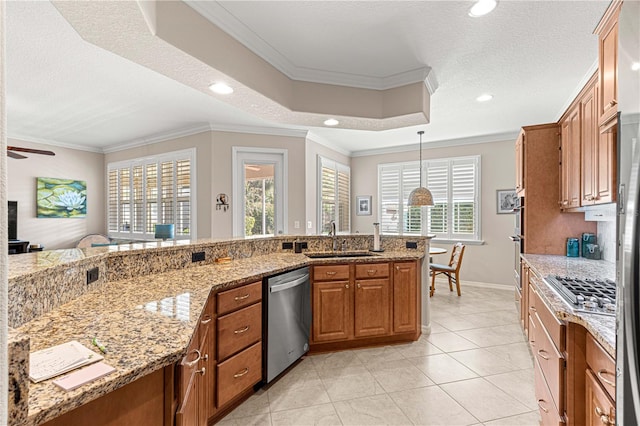 kitchen featuring appliances with stainless steel finishes, pendant lighting, sink, crown molding, and light stone countertops