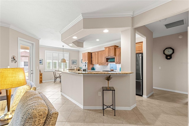 kitchen featuring light tile patterned floors, stainless steel fridge, a breakfast bar area, ornamental molding, and light stone countertops