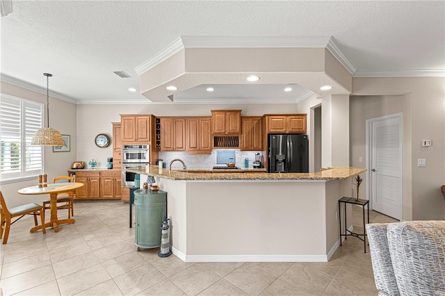 kitchen featuring a spacious island, a breakfast bar area, black fridge, light stone counters, and stainless steel double oven