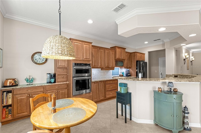 kitchen featuring black refrigerator, pendant lighting, stainless steel double oven, light stone countertops, and decorative backsplash