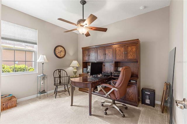 carpeted office space with a textured ceiling and ceiling fan