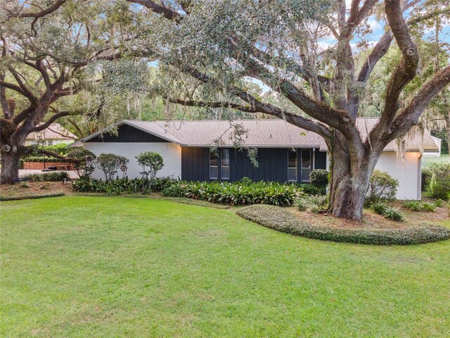 single story home with a front lawn