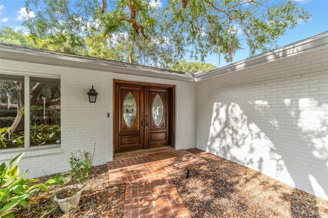 entrance to property featuring brick siding