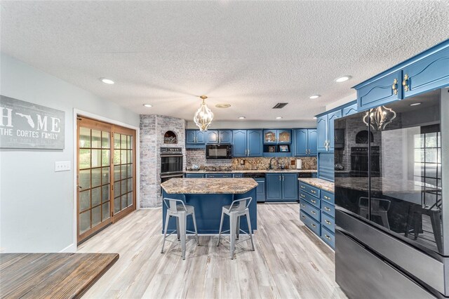 kitchen with light wood-type flooring, black appliances, decorative backsplash, and blue cabinetry