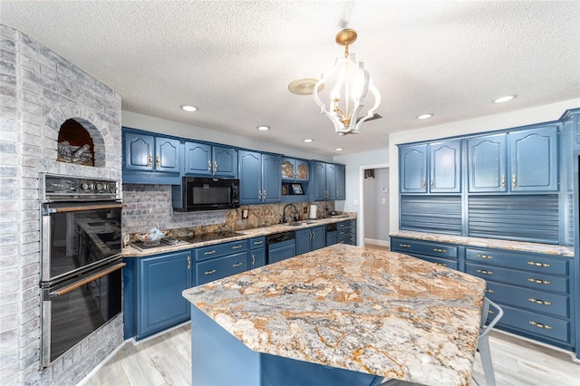 kitchen featuring blue cabinets, a sink, backsplash, black appliances, and light wood finished floors