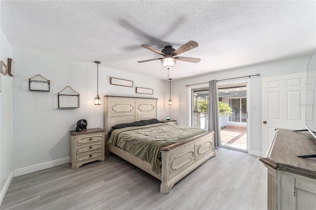 bedroom with ceiling fan, access to outside, a textured ceiling, and light hardwood / wood-style floors