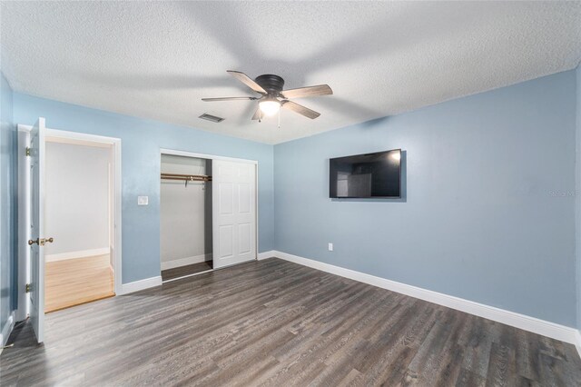 unfurnished bedroom featuring ceiling fan, hardwood / wood-style flooring, a textured ceiling, and a closet