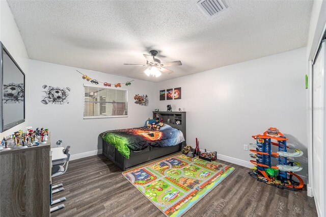 bedroom featuring ceiling fan, dark wood-type flooring, and a textured ceiling