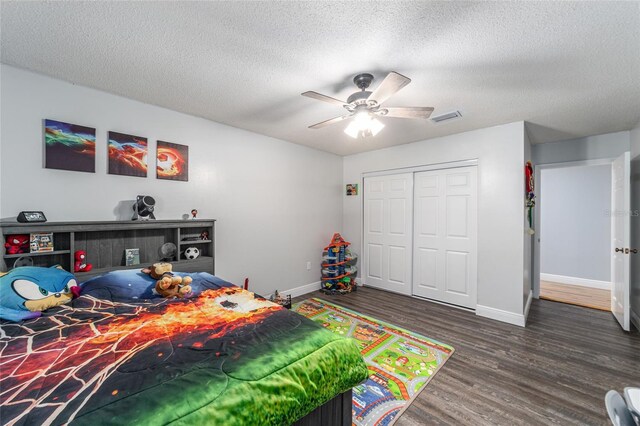 bedroom featuring baseboards, a closet, visible vents, and wood finished floors