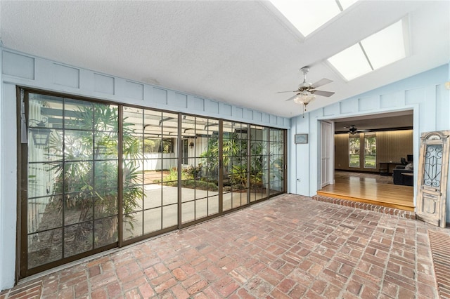 interior space featuring ceiling fan and lofted ceiling with skylight