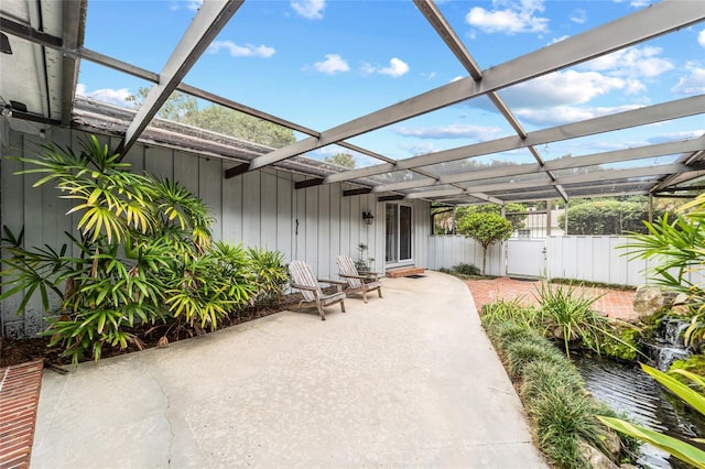 view of patio / terrace featuring a lanai and fence