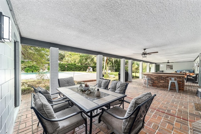 view of patio / terrace with ceiling fan, outdoor dry bar, and outdoor dining area