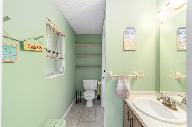 bathroom featuring tile patterned flooring, a textured ceiling, vanity, and toilet