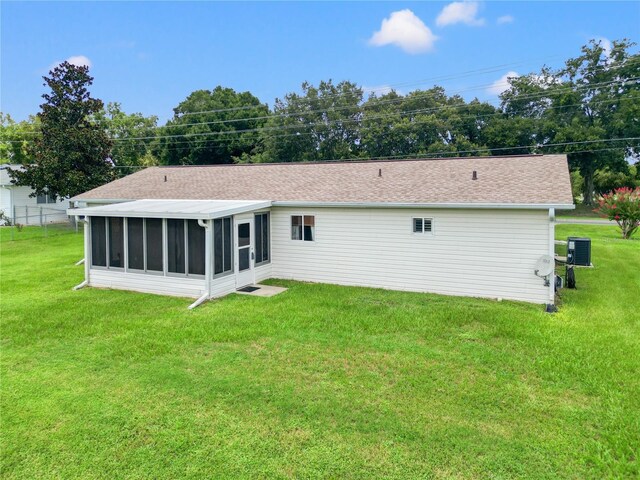 back of property featuring central AC, a sunroom, and a lawn