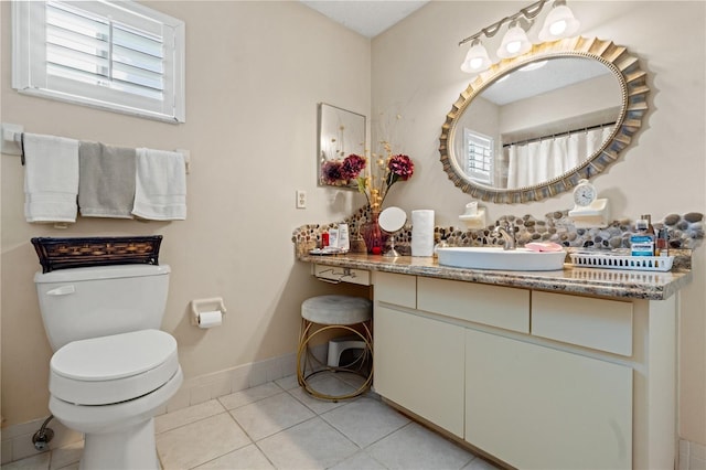 bathroom featuring toilet, vanity, and tile patterned flooring