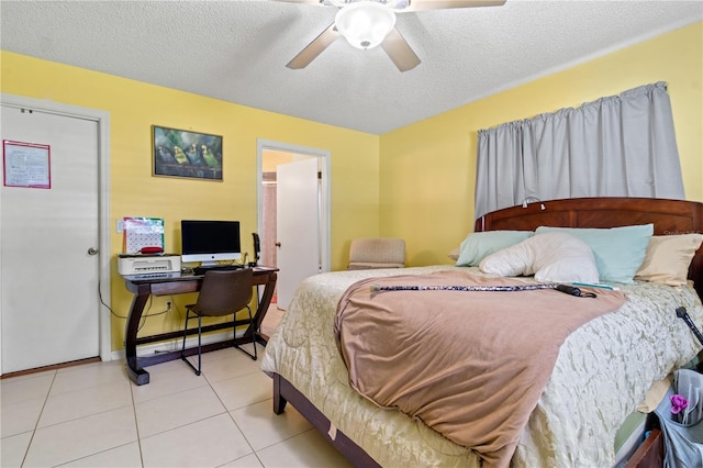 tiled bedroom with ceiling fan and a textured ceiling