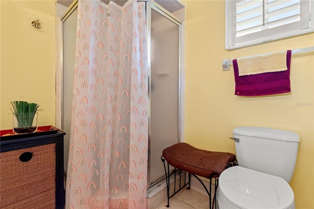 bathroom with an enclosed shower, tile patterned floors, and toilet