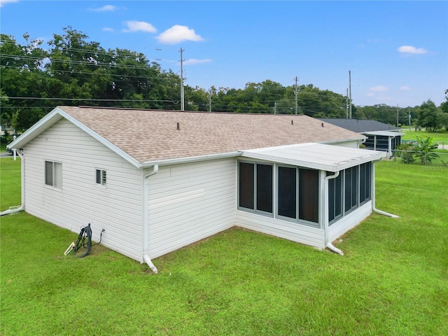 back of house with a lawn and a sunroom