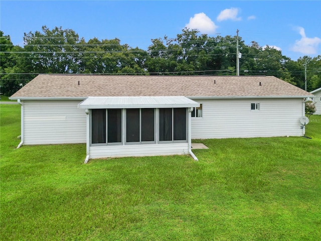 rear view of house with a lawn and a sunroom