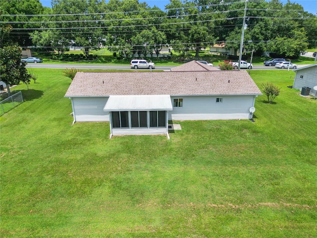 rear view of property with a yard and a sunroom