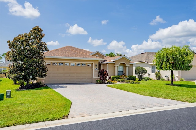 ranch-style home featuring a garage and a front lawn