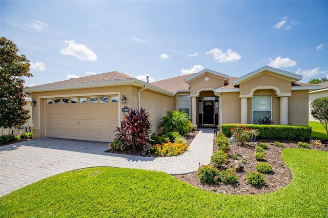 ranch-style house with a garage and a front lawn