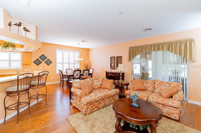 living room featuring light hardwood / wood-style floors and a notable chandelier