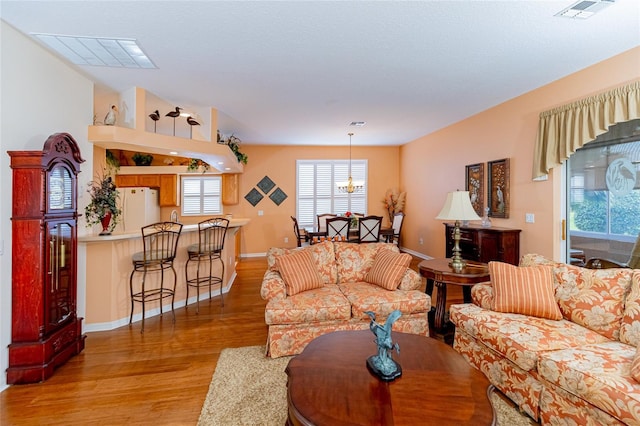 living room featuring light hardwood / wood-style flooring and a notable chandelier