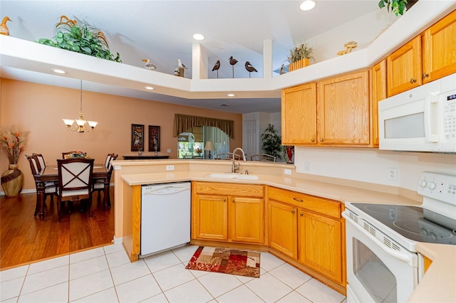 kitchen featuring light tile patterned flooring, sink, a chandelier, kitchen peninsula, and white appliances