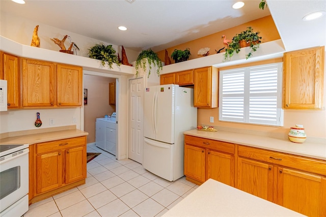 kitchen with light tile patterned floors, white appliances, and independent washer and dryer