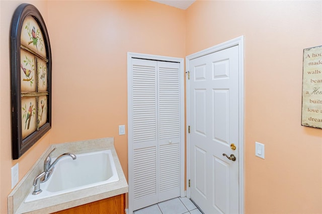 bathroom featuring sink, a bath, and tile patterned floors