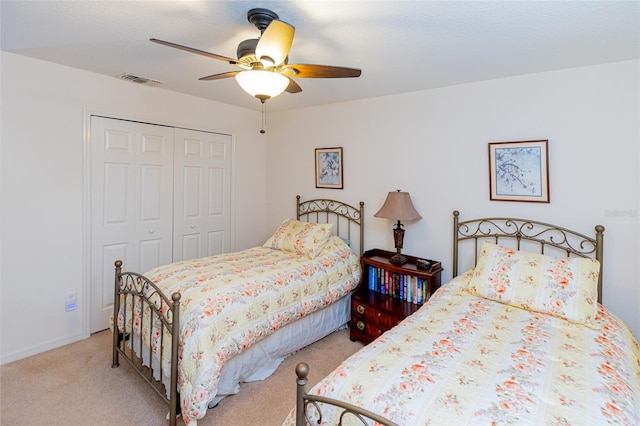 bedroom with light colored carpet, ceiling fan, and a closet