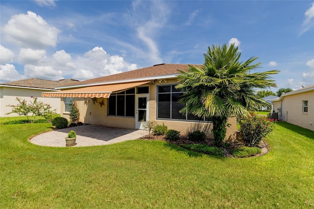 rear view of house with a patio and a yard