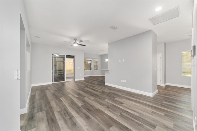 unfurnished living room featuring plenty of natural light, dark hardwood / wood-style floors, and ceiling fan