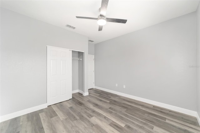 unfurnished bedroom featuring a closet, ceiling fan, and light wood-type flooring