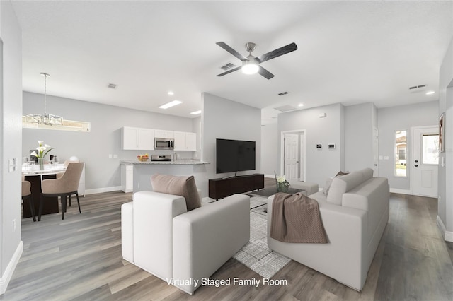 living room with ceiling fan and light hardwood / wood-style floors