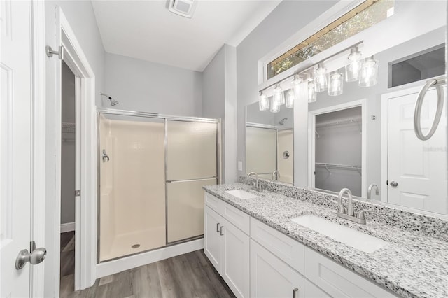 bathroom with wood-type flooring, an enclosed shower, and vanity