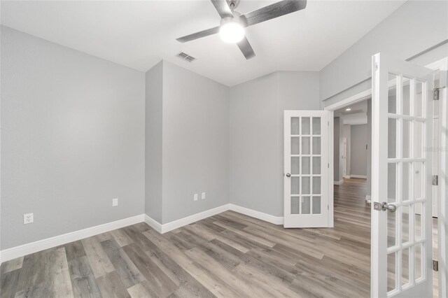 unfurnished room with french doors, ceiling fan, and light wood-type flooring