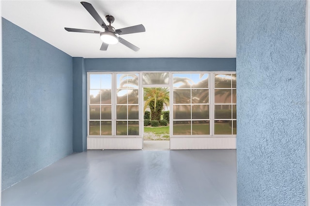 entryway featuring ceiling fan and concrete flooring