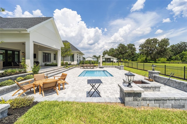 view of pool with a patio, an outdoor fire pit, and a lawn