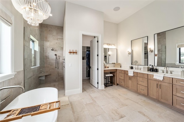 full bath with a soaking tub, a spacious closet, an inviting chandelier, a tile shower, and vanity