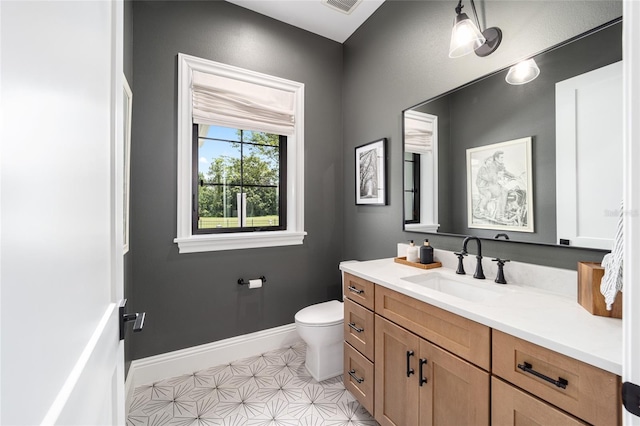 bathroom with toilet, visible vents, baseboards, and vanity