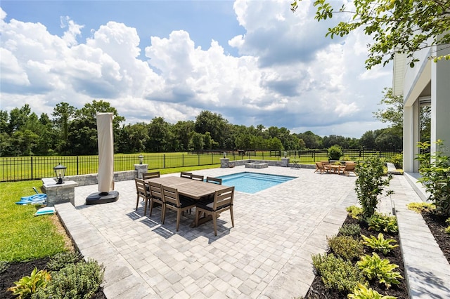 view of swimming pool featuring a yard, a patio, and a rural view