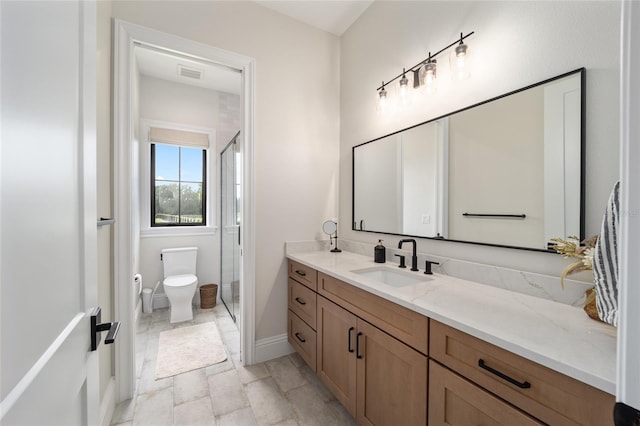 bathroom with a shower with door, vanity, and toilet