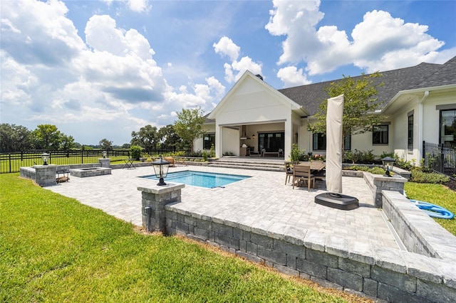 view of swimming pool featuring a patio, an outdoor fire pit, and a lawn