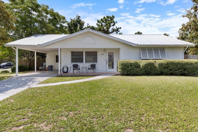 ranch-style home with a front lawn, a carport, concrete driveway, metal roof, and brick siding