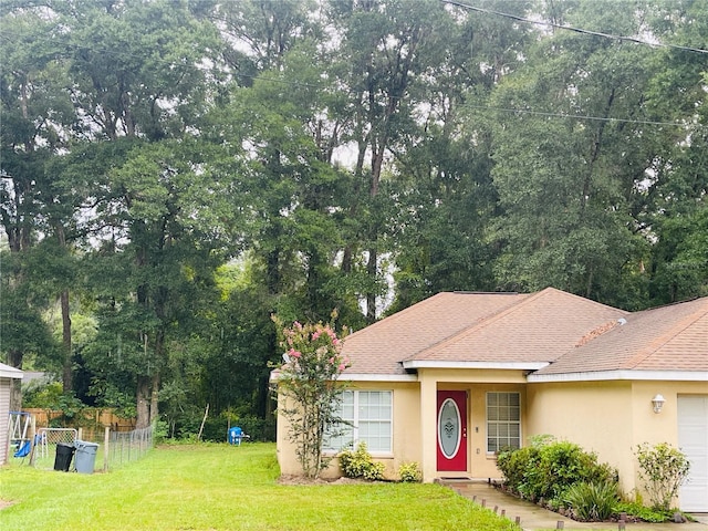 single story home featuring a garage, a playground, and a front lawn