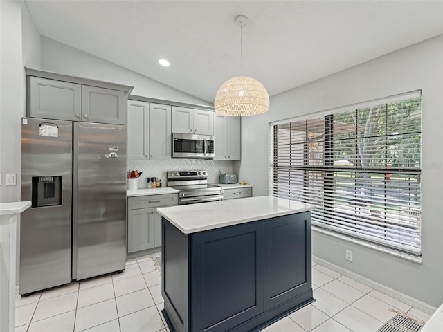 kitchen featuring lofted ceiling, stainless steel appliances, light countertops, gray cabinets, and decorative backsplash