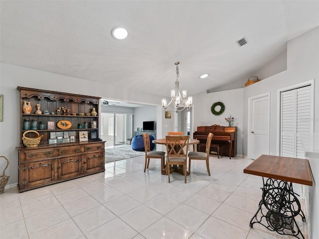 dining space featuring vaulted ceiling, light tile patterned flooring, visible vents, and an inviting chandelier